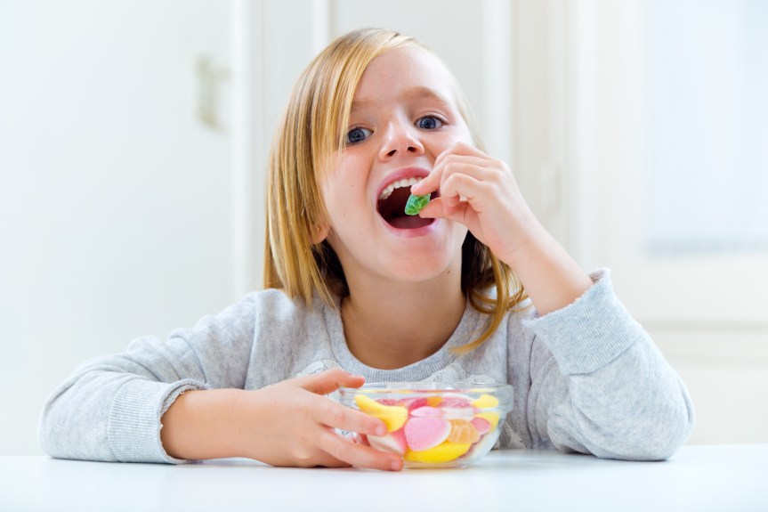 Beautiful child eating sweets at home.